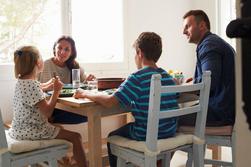 Barnfamilj som &auml;ter tillsammans i k&ouml;ket.